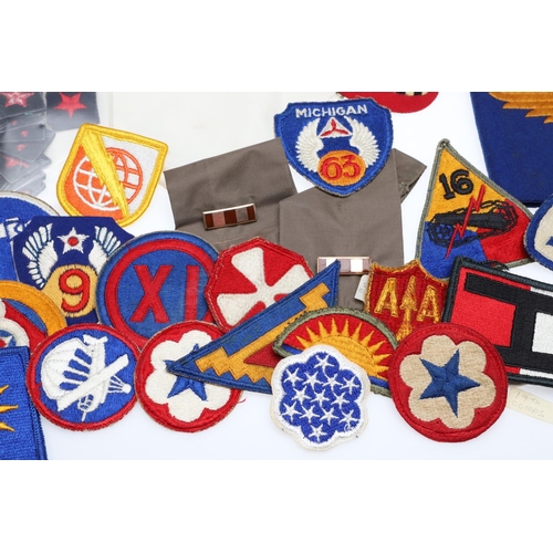 265 - A COLLECTION OF AMERICAN HAT INSIGNIA AND OTHER BADGES AND PATCHES. A mounted collection of crossed ... 