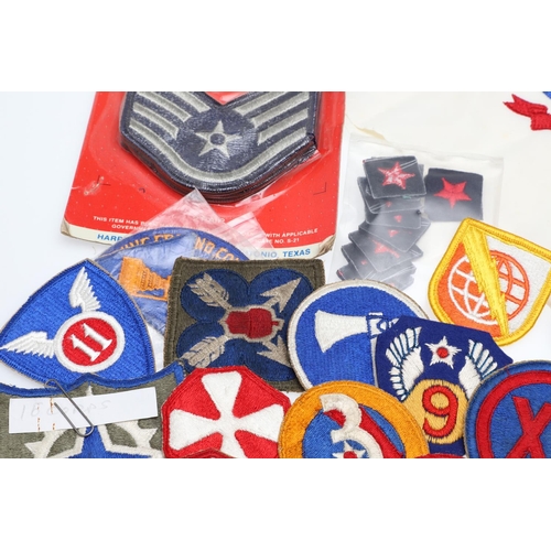 265 - A COLLECTION OF AMERICAN HAT INSIGNIA AND OTHER BADGES AND PATCHES. A mounted collection of crossed ... 