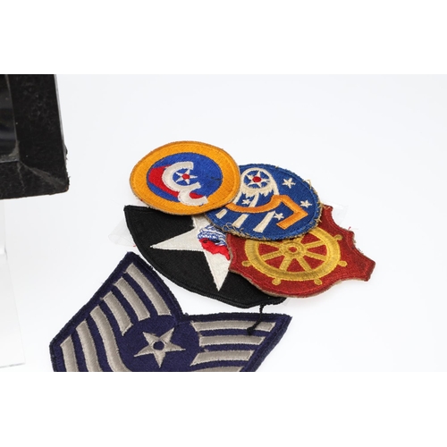 265 - A COLLECTION OF AMERICAN HAT INSIGNIA AND OTHER BADGES AND PATCHES. A mounted collection of crossed ... 