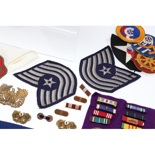 265 - A COLLECTION OF AMERICAN HAT INSIGNIA AND OTHER BADGES AND PATCHES. A mounted collection of crossed ... 