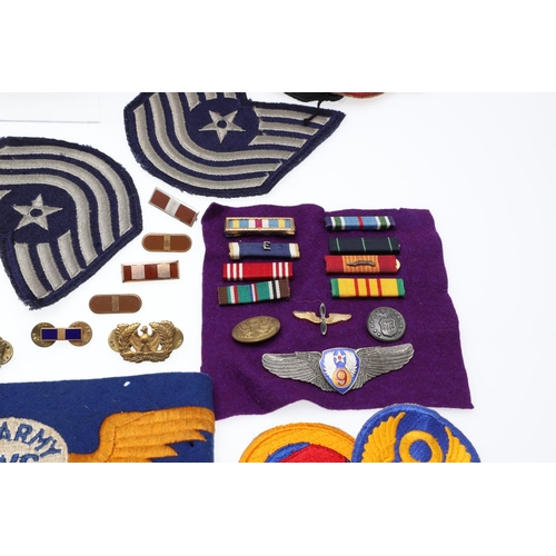 265 - A COLLECTION OF AMERICAN HAT INSIGNIA AND OTHER BADGES AND PATCHES. A mounted collection of crossed ... 