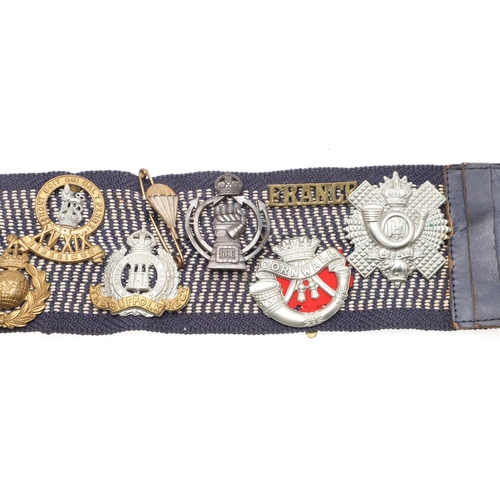 271 - A BELT OF SECOND WORLD WAR CAP BADGES WITH LINKS TO THE SPECIAL OPERATIONS EXECUTIVE. A collection o... 