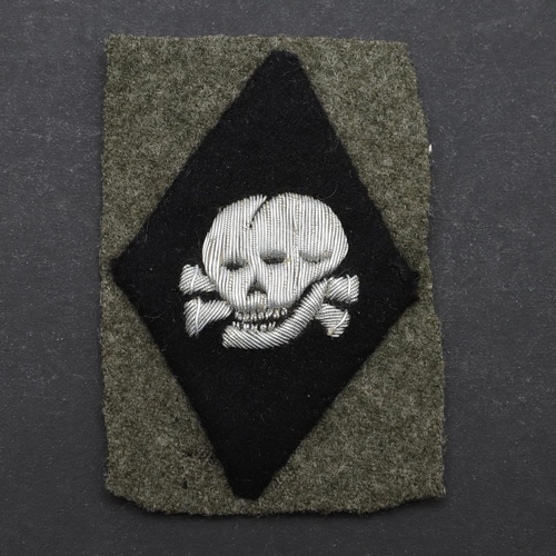 345 - A SECOND WORLD WAR GERMAN WAFFEN-SS OFFICER's  SKULL ARMBADGE. A Waffen-SS Officer's  'Totenkopf' sk... 