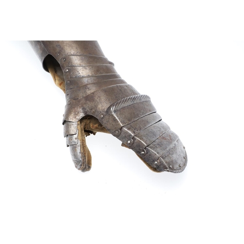 396 - A MID 16TH CENTURY MITTEN GAUNTLET. A steel mitten gauntlet for the left hand, with a flared tubular... 