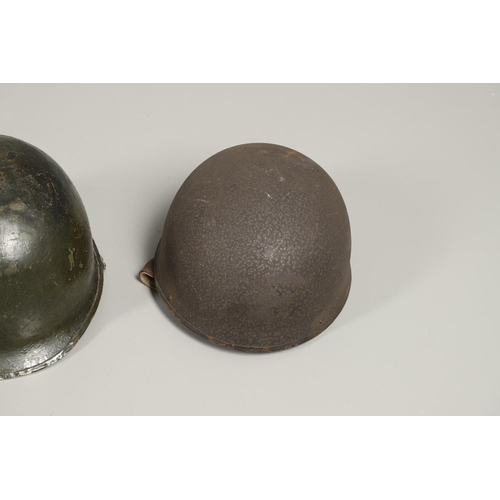 435 - THREE SECOND WORLD WAR OR LATER AMERICAN HELMETS. An American Steel helmet with green painted shell,... 