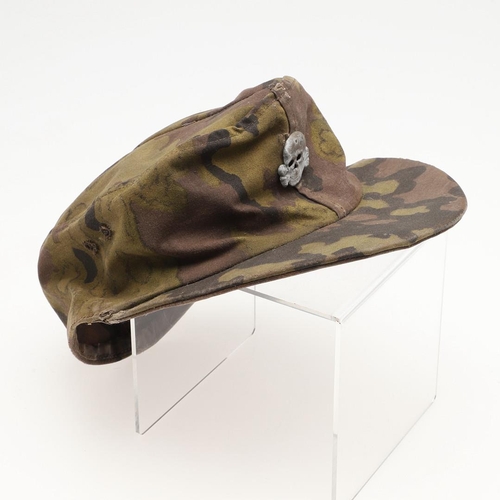 447 - A SECOND WORLD WAR GERMAN WAFFEN-SS CAMOUFLAGE SKI CAP. A camouflage pattern ski cap with a zinc sku... 