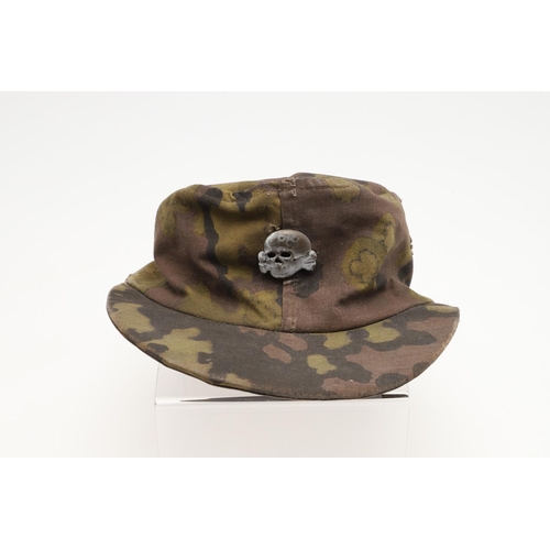 447 - A SECOND WORLD WAR GERMAN WAFFEN-SS CAMOUFLAGE SKI CAP. A camouflage pattern ski cap with a zinc sku... 