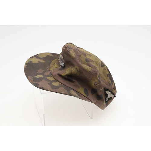 447 - A SECOND WORLD WAR GERMAN WAFFEN-SS CAMOUFLAGE SKI CAP. A camouflage pattern ski cap with a zinc sku... 