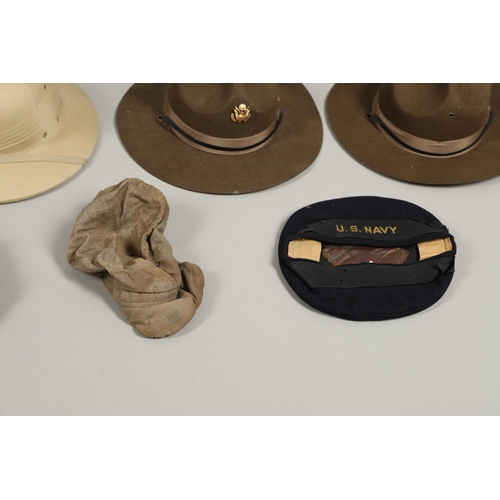 448 - A COLLECTION OF AMERICAN MILITARY HATS TO INCLUDE TWO US NAVY SUN HELMETS. Two US sun helmets, one m... 