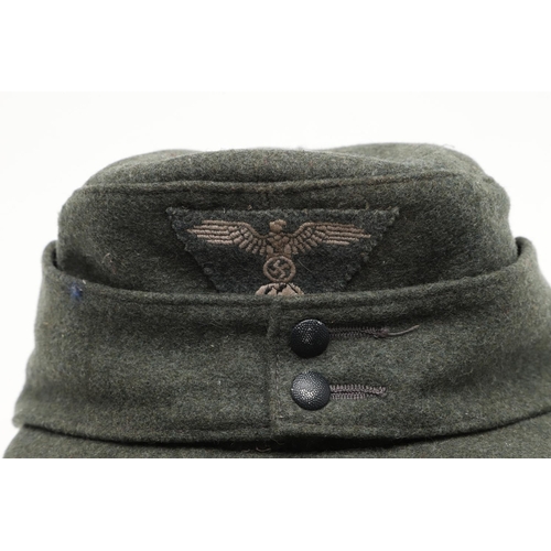 452 - A SECOND WORLD WAR GERMAN WAFFEN-SS M43 TYPE CAP. A fieldgrey cap, the fabric badge with an eagle ov... 