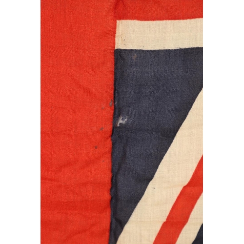 543 - A COLLECTION OF BRITISH FLAGS: TWO UNION JACKS, A RED AND WHITE ENSIGN. A Union Jack of sewn constru... 