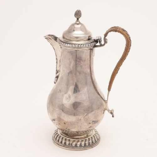 101 - A LATE VICTORIAN SILVER HOT WATER JUG. baluster form, with gadrooned borders, a cane-insulated handl... 