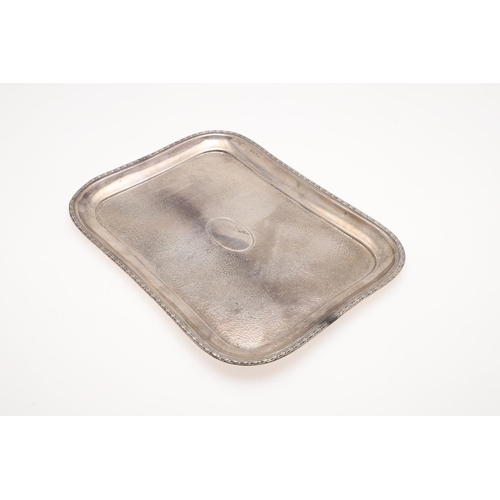 122 - AN EDWARDIAN SILVER DRESSING TABLE TRAY. shaped rectangular outline, with a spot-hammered centre and... 