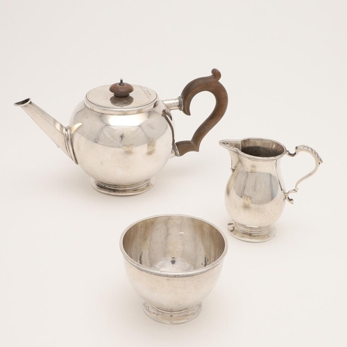 124 - AN EARLY 20TH CENTURY THREE-PIECE SILVER TEA SET. the teapot of 'bullet' form, with a sparrow-beak m... 