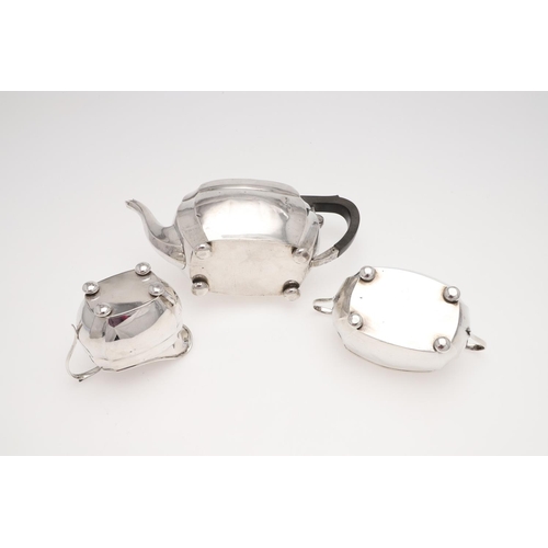 130 - A GEORGE V THREE-PIECE SILVER TEA SET. rounded rectangular, with cut corners and raised on bun feet,... 