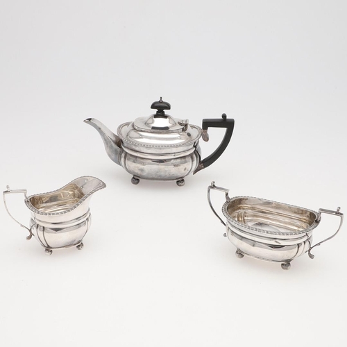 131 - AN EDWARDIAN SMALL OR BACHELOR'S THREE PIECE SILVER TEA SET. rounded rectangular, with gadrooned bor... 