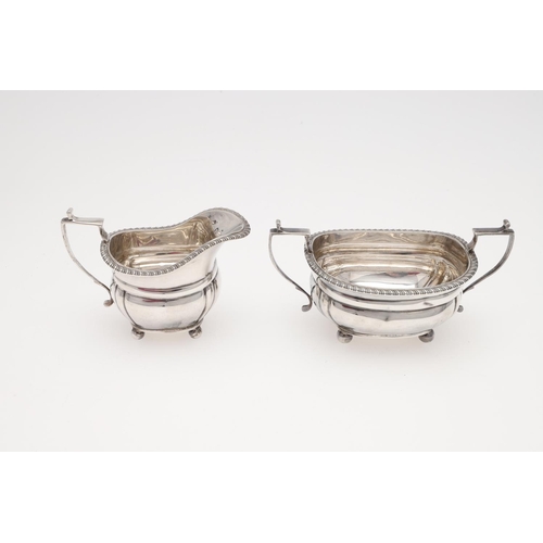 131 - AN EDWARDIAN SMALL OR BACHELOR'S THREE PIECE SILVER TEA SET. rounded rectangular, with gadrooned bor... 