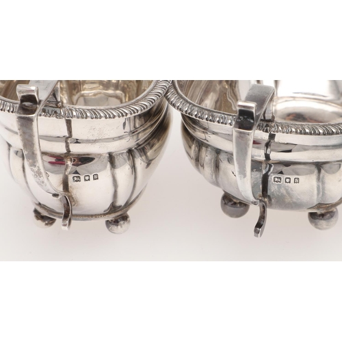 131 - AN EDWARDIAN SMALL OR BACHELOR'S THREE PIECE SILVER TEA SET. rounded rectangular, with gadrooned bor... 