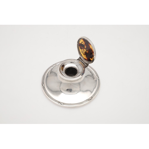 139 - A GEORGE V SILVER INKWELL. circular form, with ribbon & reed borders and the tortoiseshell mounted c... 