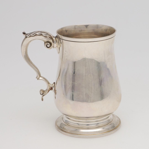 140 - AN ELIZABETH II SILVER PINT MUG. baluster form, with a leaf-capped 'S'-scroll handle and on a spread... 