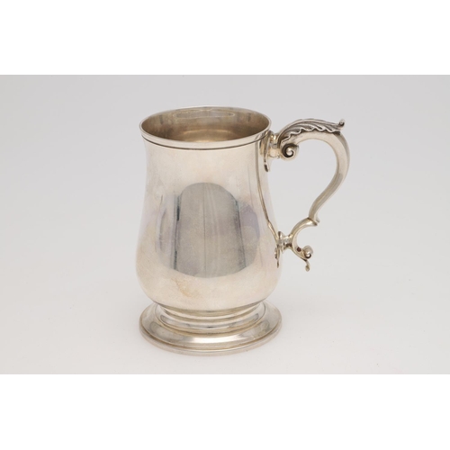 140 - AN ELIZABETH II SILVER PINT MUG. baluster form, with a leaf-capped 'S'-scroll handle and on a spread... 