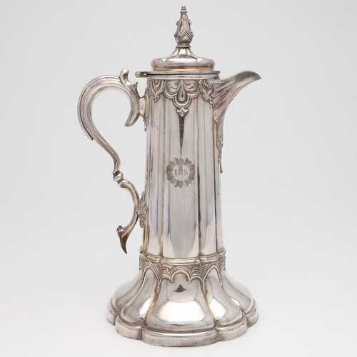 145 - A LARGE SILVER PLATED COMMUNION FLAGON. lobed circular form, with applied decoration and a scroll ha... 