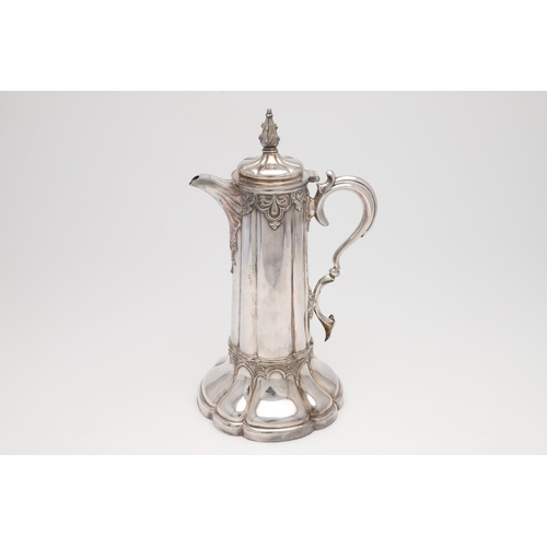 145 - A LARGE SILVER PLATED COMMUNION FLAGON. lobed circular form, with applied decoration and a scroll ha... 