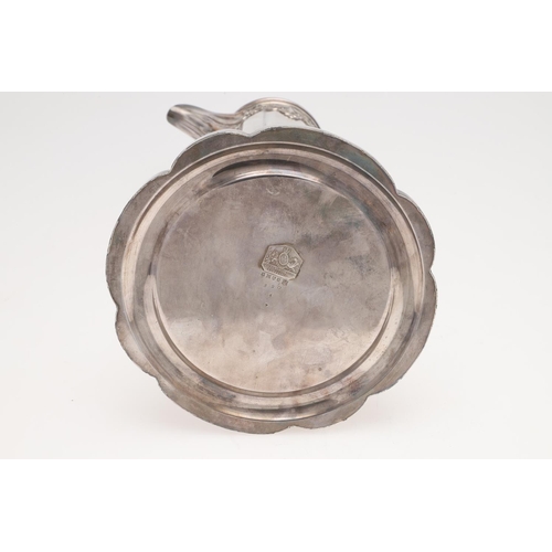 145 - A LARGE SILVER PLATED COMMUNION FLAGON. lobed circular form, with applied decoration and a scroll ha... 