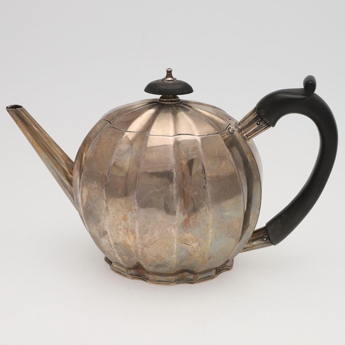 146 - A GEORGE III SILVER TEAPOT. of melon fluted form, with a scroll handle and raised on a shaped foot, ... 