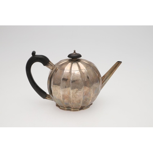 146 - A GEORGE III SILVER TEAPOT. of melon fluted form, with a scroll handle and raised on a shaped foot, ... 