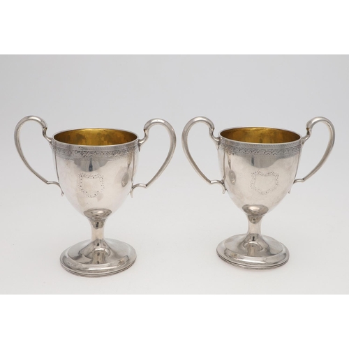 149 - A PAIR OF GEORGE III IRISH SILVER TWO-HANDLED CUPS. campana form, with twin scroll handles, an engra... 