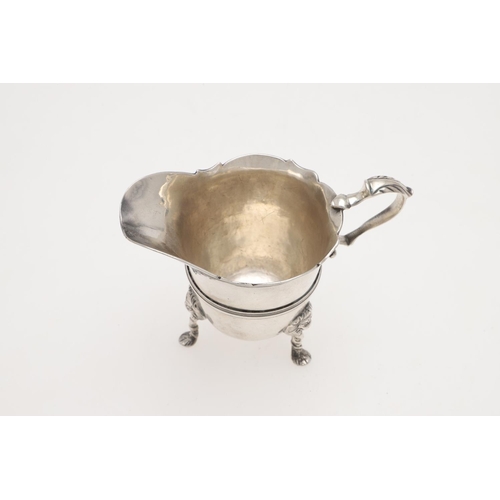 154 - A GEORGE II HELMET-SHAPED IRISH SILVER CREAM JUG. raised on three lion mask legs, with a reeded cent... 