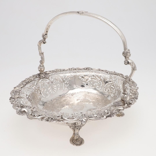 161 - A GEORGE II SWING-HANDLE SILVER CAKE BASKET. with a flat-chased centre, applied floral scroll border... 