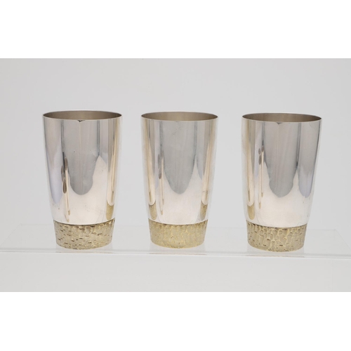 165 - A SET OF SIX ELIZABETH II PARCELGILT TUMBLERS, BY STUART DEVLIN. circular and with textured bases, L... 