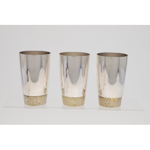 165 - A SET OF SIX ELIZABETH II PARCELGILT TUMBLERS, BY STUART DEVLIN. circular and with textured bases, L... 