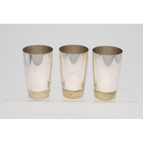 165 - A SET OF SIX ELIZABETH II PARCELGILT TUMBLERS, BY STUART DEVLIN. circular and with textured bases, L... 