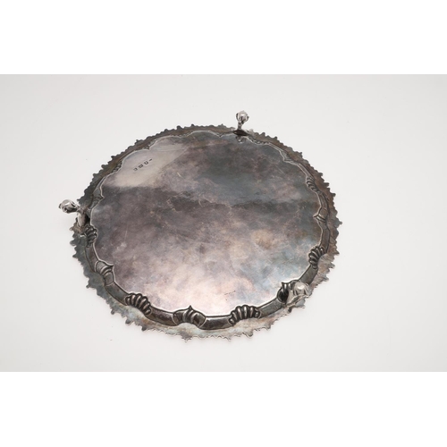 178 - A GEORGE III SILVER SALVER. shaped circular outline, with a gadroon & shell border, engraved arms to... 