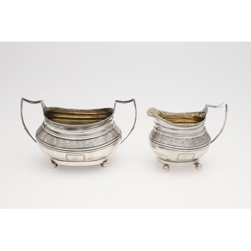 182 - A GEORGE III THREE-PIECE SILVER TEA SET. rounded oblong form, with engraved borders, a central friez... 