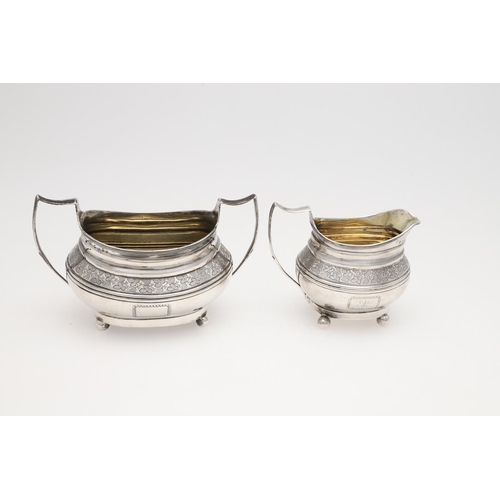 182 - A GEORGE III THREE-PIECE SILVER TEA SET. rounded oblong form, with engraved borders, a central friez... 