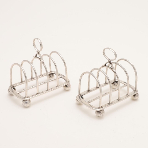 188 - A PAIR OF LATE VICTORIAN SILVER TOAST RACKS. with six arched bars, a central loop handle and on four... 