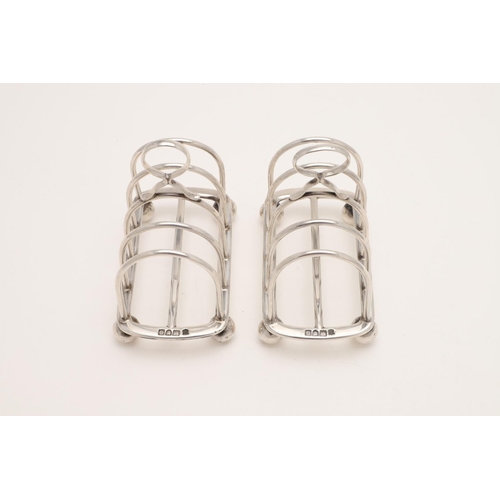 188 - A PAIR OF LATE VICTORIAN SILVER TOAST RACKS. with six arched bars, a central loop handle and on four... 