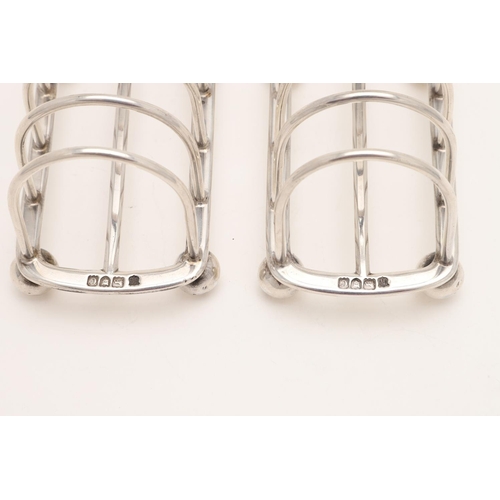 188 - A PAIR OF LATE VICTORIAN SILVER TOAST RACKS. with six arched bars, a central loop handle and on four... 