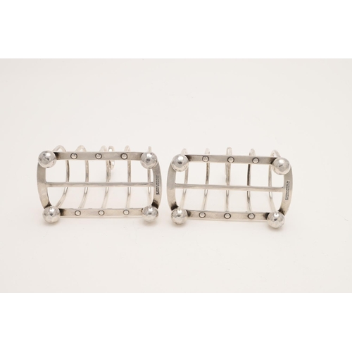 188 - A PAIR OF LATE VICTORIAN SILVER TOAST RACKS. with six arched bars, a central loop handle and on four... 