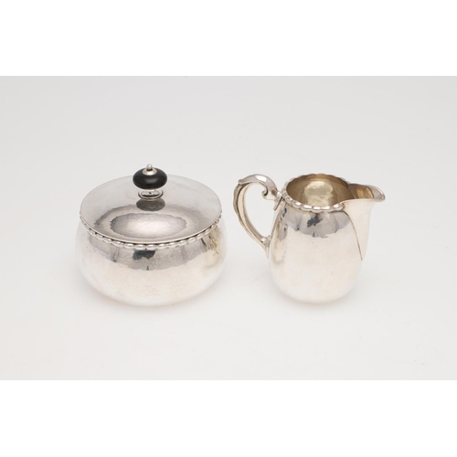 193 - AN EARLY 20TH CENTURY THREE-PIECE CONTINENTAL SILVER SUGAR & CREAM SET. with a spot-hammered finish,... 