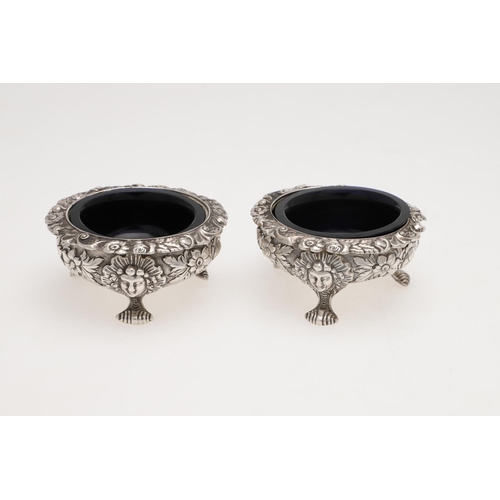 203 - A PAIR OF WILLIAM IV SCOTTISH SILVER SALTS. squat circular, with foliate borders and embossed & chas... 