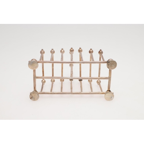 208 - A LATE VICTORIAN SILVER TOAST RACK. in the style of Christopher Dresser, with six divisions, straigh... 