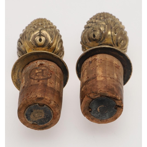 211 - A PAIR OF FRENCH SILVERGILT BOTTLE STOPPERS. with bud finials and acanthus leaves around the lower s... 