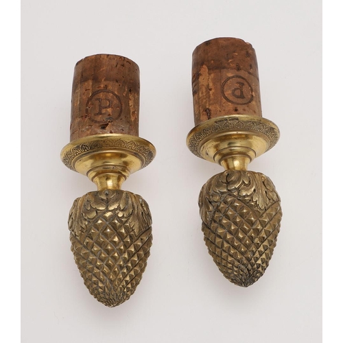 211 - A PAIR OF FRENCH SILVERGILT BOTTLE STOPPERS. with bud finials and acanthus leaves around the lower s... 