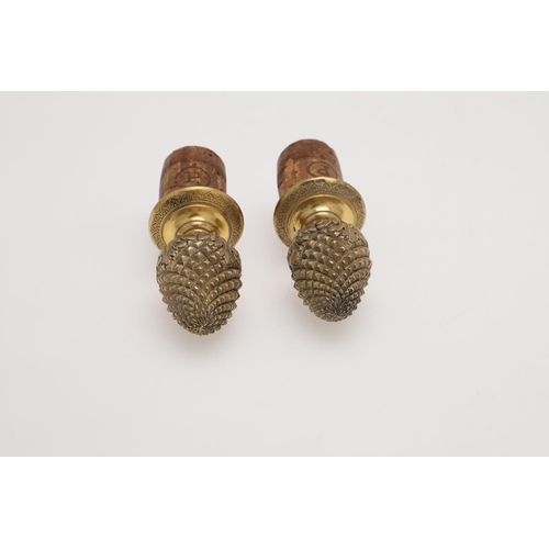 211 - A PAIR OF FRENCH SILVERGILT BOTTLE STOPPERS. with bud finials and acanthus leaves around the lower s... 