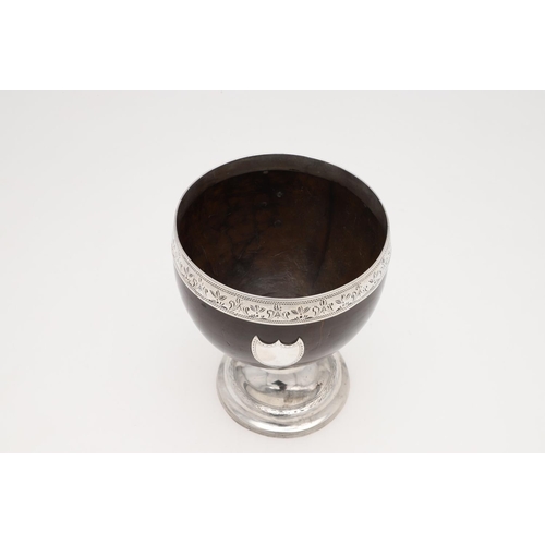 216 - A GEORGE III SILVER MOUNTED COCONUT CUP. circular form, with a bright engraved frieze, an applied va... 